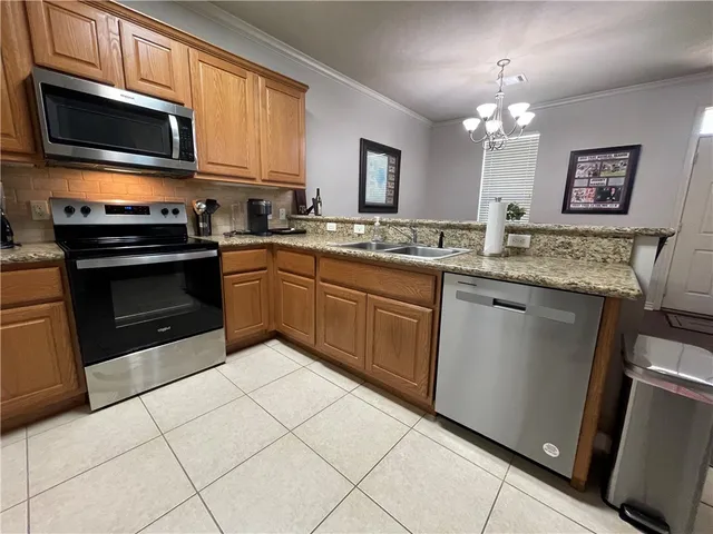a kitchen with stainless steel appliances granite countertop a stove top oven a sink dishwasher and white cabinets