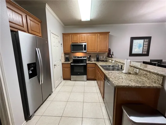 a kitchen with stainless steel appliances granite countertop a refrigerator stove and sink