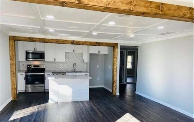 a large kitchen with stainless steel appliances granite countertop a stove and a refrigerator