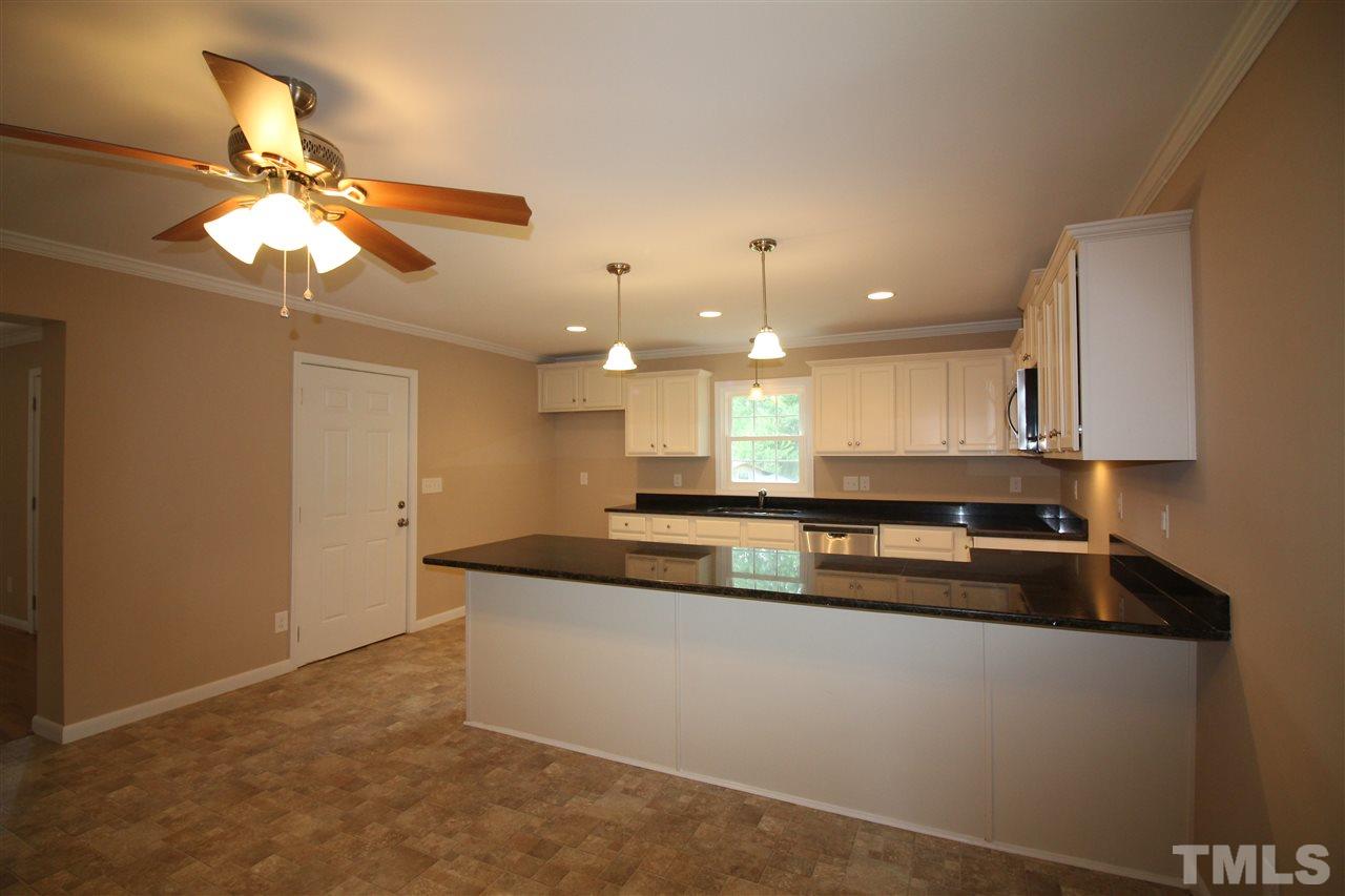 6332 Rock Quarry Road Raleigh, NC 27610 - Photo 8 of 17 a kitchen with kitchen island a counter top space appliances and cabinets