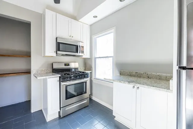 a kitchen with granite countertop a stove and a microwave