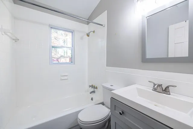 a bathroom with a sink toilet vanity and shower