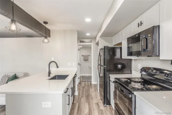 a kitchen with stainless steel appliances a stove a sink a refrigerator and cabinets