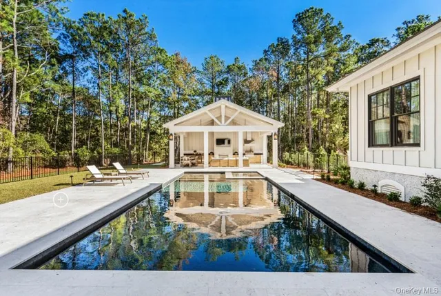 a view of house with swimming pool and outdoor seating