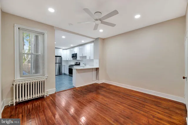 an open kitchen with wooden floor and a window