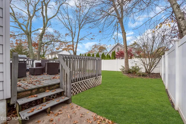 a view of backyard with wooden fence