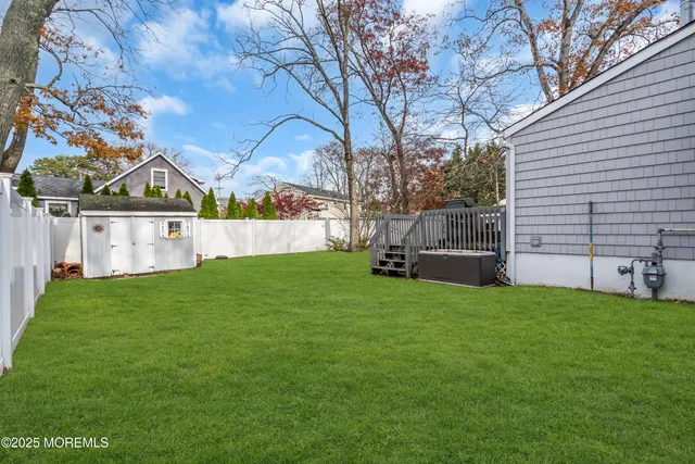 a view of a house with backyard and a tree
