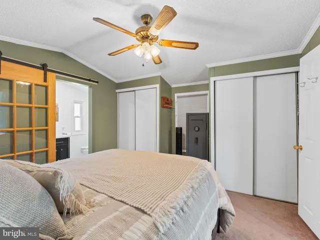 a bedroom with a large bed and ceiling fan