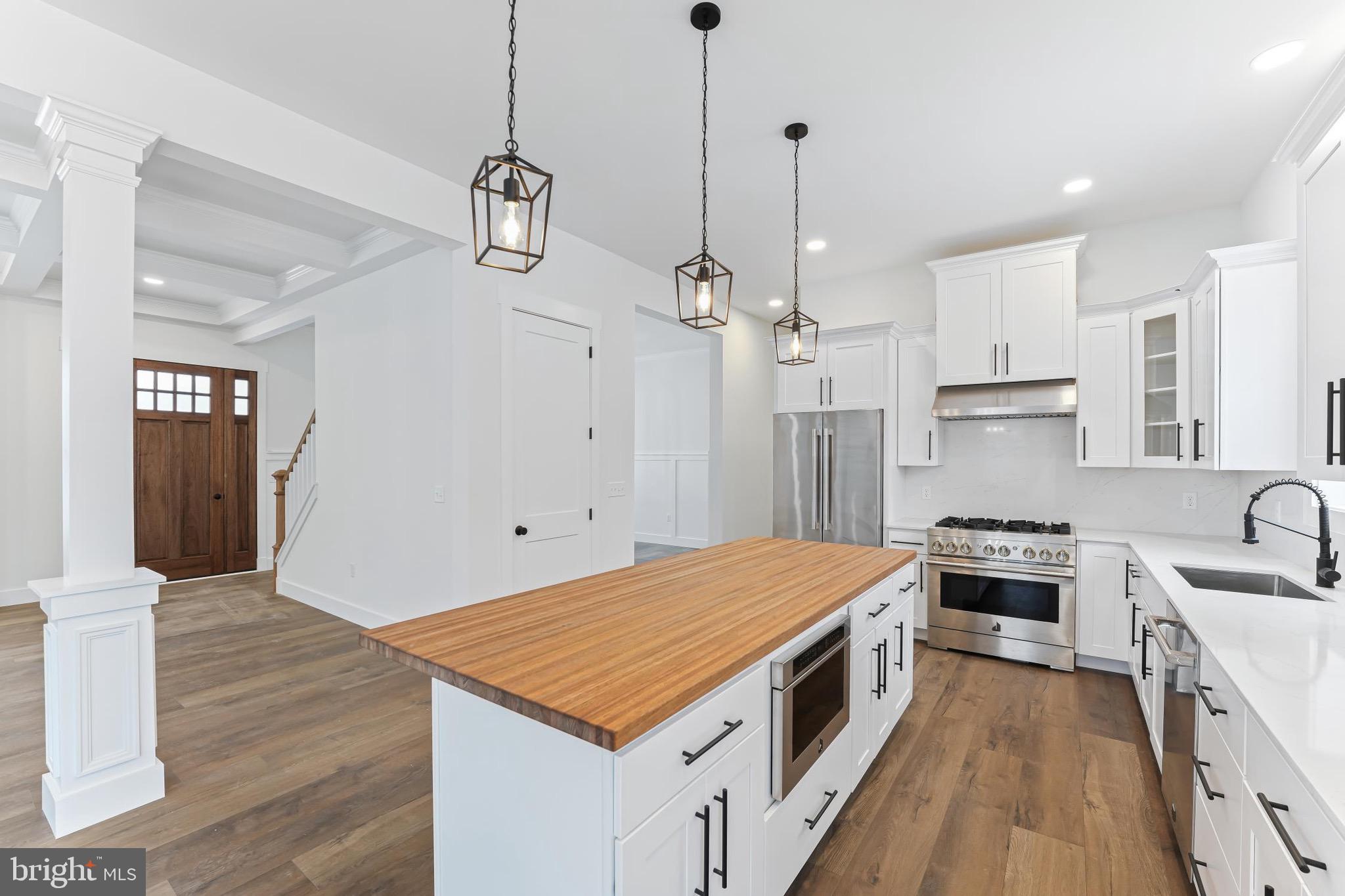 167 Ellicott Road Avondale, PA 19311 - Photo 13 of 54 a kitchen with kitchen island a stove a sink a center island and wooden floor