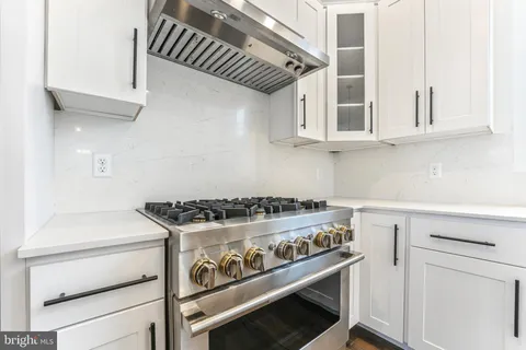 a stove top oven sitting inside of a kitchen