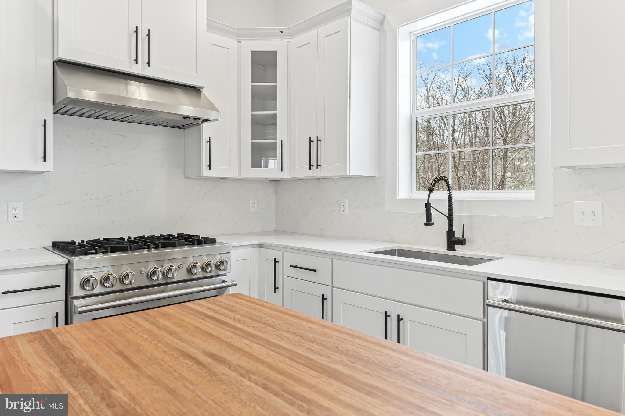 167 Ellicott Road Avondale, PA 19311 - Photo 21 of 54 a kitchen with stainless steel appliances granite countertop a stove a sink and white cabinets