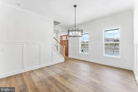 a view of a room with wooden floor chandelier and windows