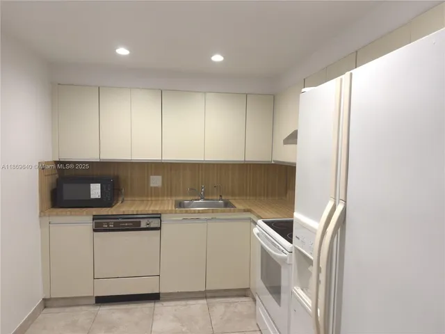 a view of washer and dryer with kitchen in the background