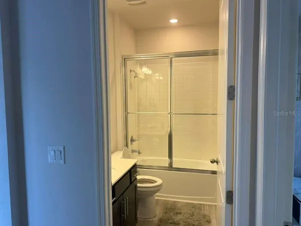 a bathroom with a granite countertop sink toilet and shower