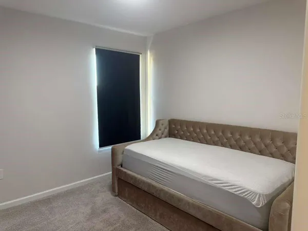 a bedroom with a bed and a window