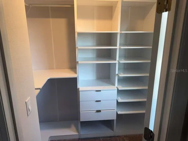 a view of walk in closet with empty racks