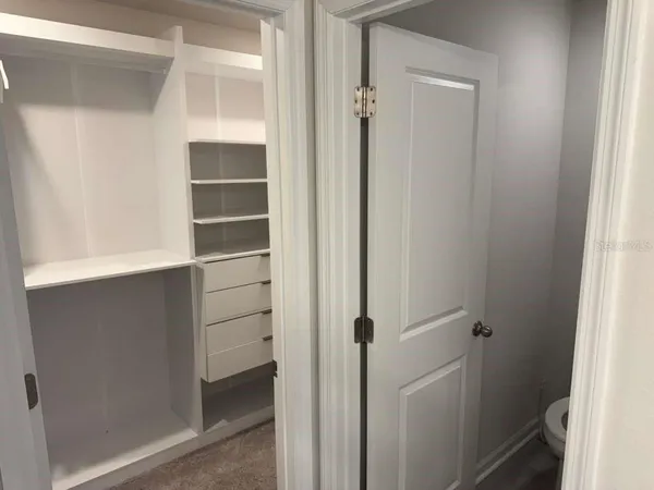 a view of walk in closet with empty racks
