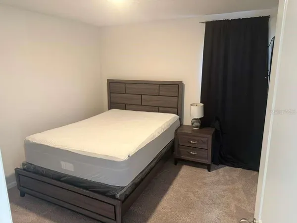 a bed sitting in a bedroom next to a cabinet