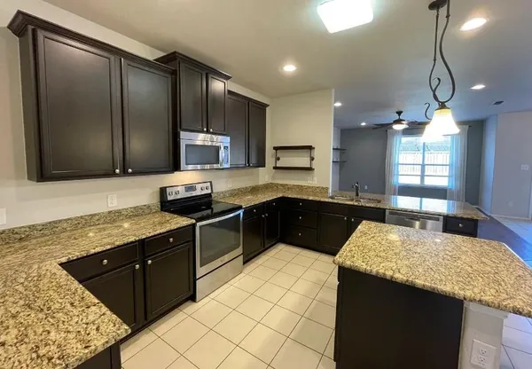 a kitchen with a sink a stove top oven a refrigerator and a oven