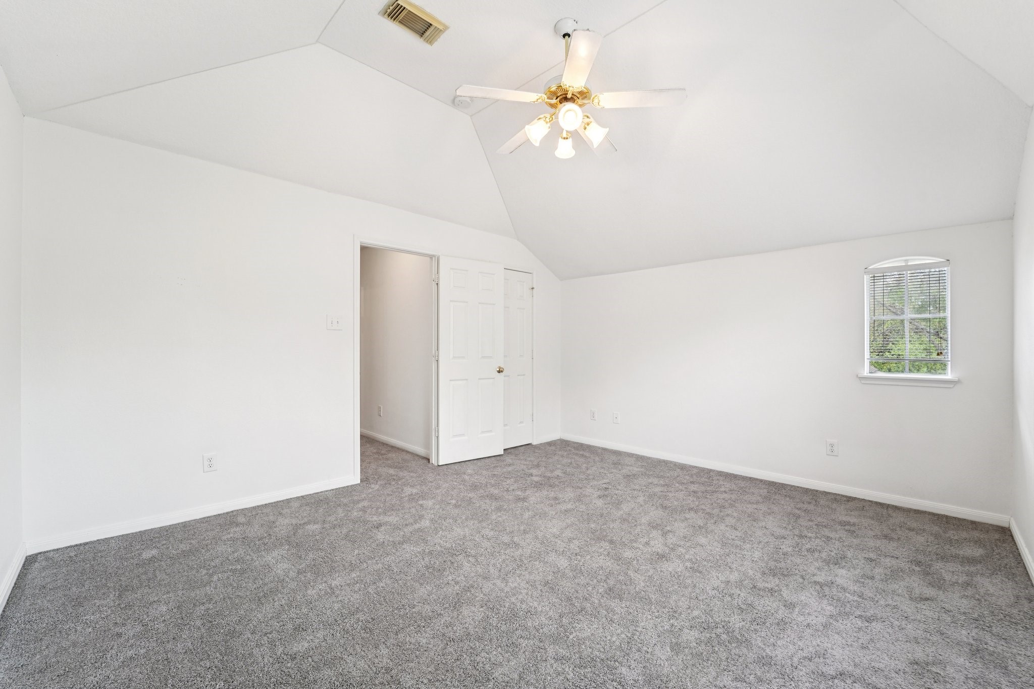 14420 Walters Road, Unit 55 Houston, TX 77014 - Photo 28 of 35 Bright, spacious room with fresh white walls and gray carpet. Features a ceiling fan, arched window, and ample natural light. Ideal for a bedroom or office.