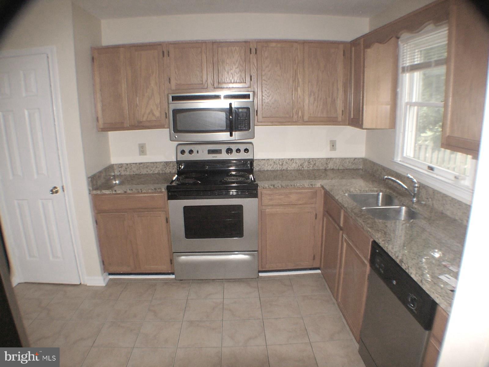 Kitchen has granite counters & oak cabinets.