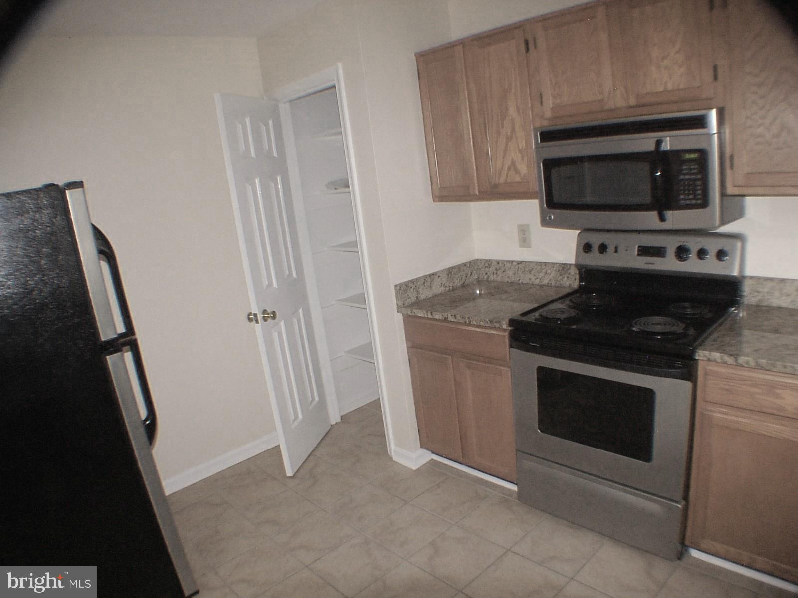 Kitchen has stainless appliances and a pantry
