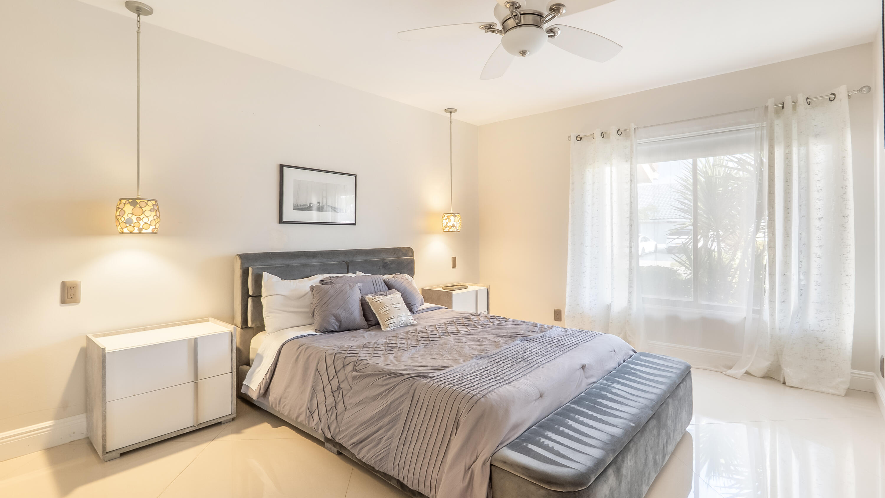 10571 Boca Woods Lane Boca Raton, FL 33428 - Photo 30 of 81 a bedroom with a large bed and a chandelier