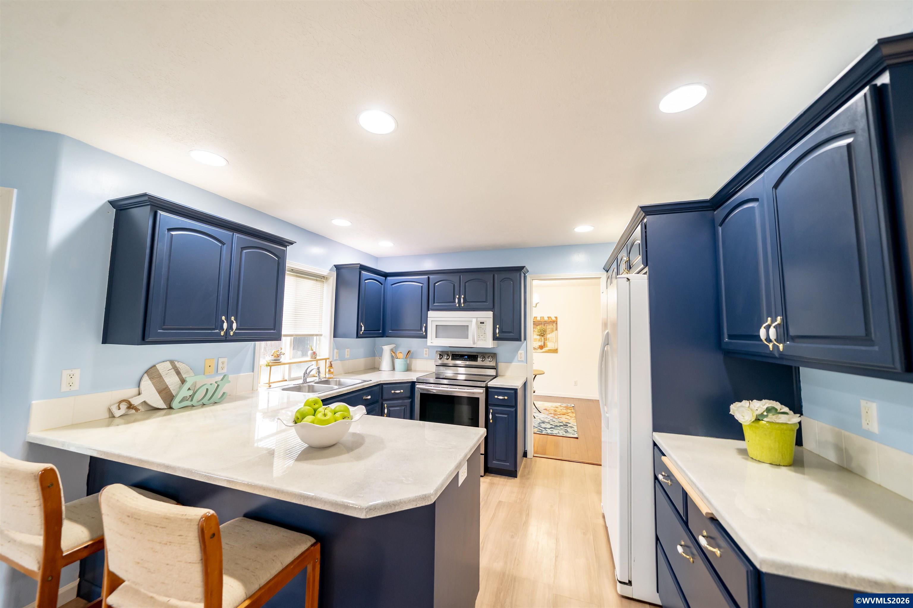 312 Southwest Cascade Meadow Drive Sublimity, OR 97385 - Photo 11 of 42 a kitchen with a refrigerator a stove a sink a dining table and chairs