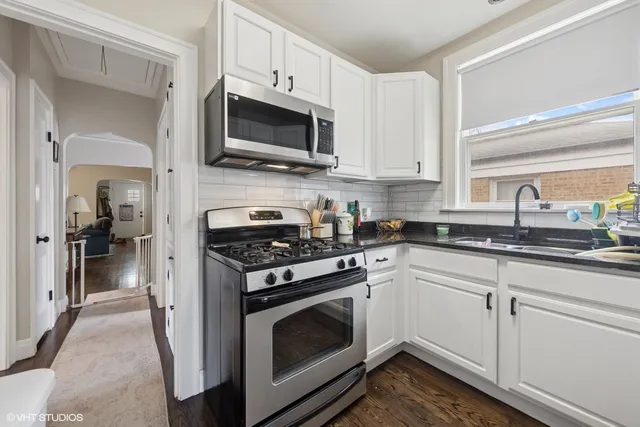 a kitchen with white cabinets and stainless steel appliances
