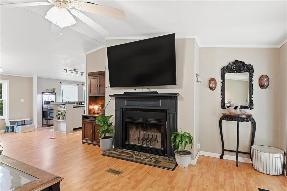 1014 Harris Road Anderson, SC 29625 - Photo 3 of 34 Warm wood floors and a stately fireplace anchor this inviting living area, open to the kitchen beyond.