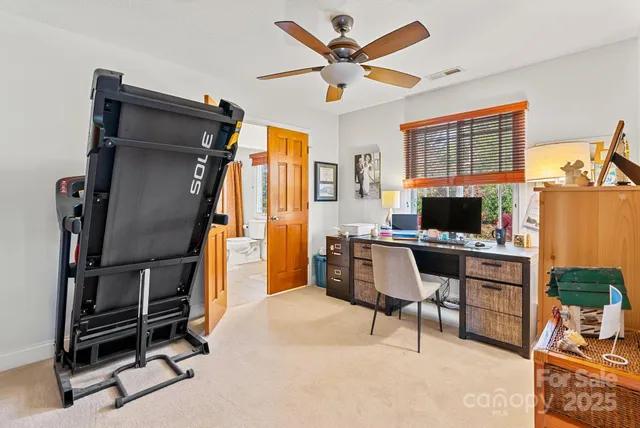 a bedroom with a bed and a ceiling fan