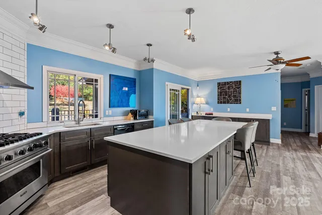 a kitchen with a stove a sink a dining table and chairs