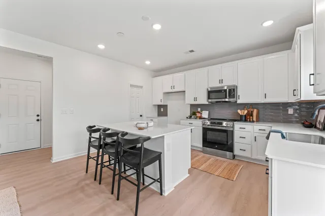 a kitchen with a sink and chairs