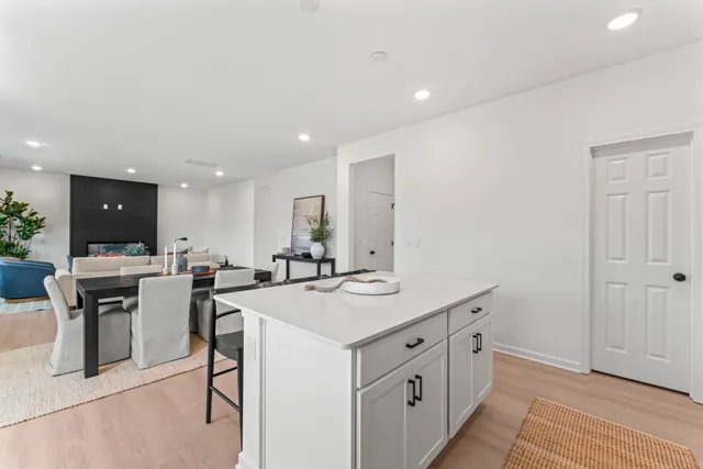 a kitchen with a dining table chairs and white cabinets