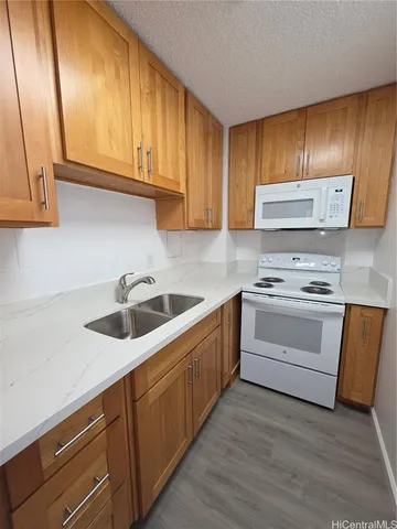 a kitchen with granite countertop wooden cabinets and white appliances