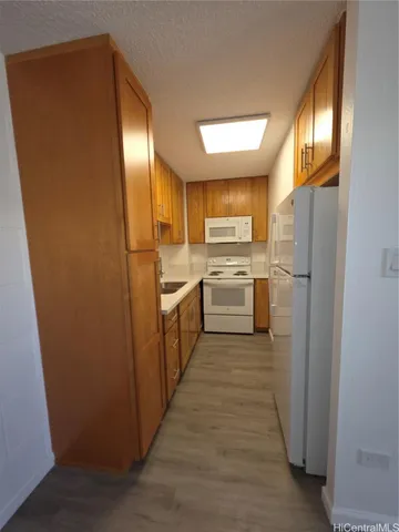 a kitchen with cabinets a refrigerator and a sink