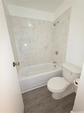 a white toilet sitting next to a bath tub
