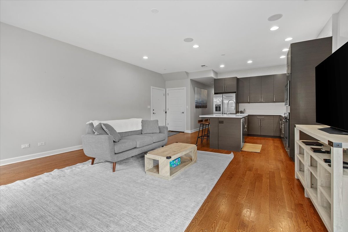 2112 West Rice Street, Unit 2 Chicago, IL 60622 - Photo 6 of 19 a living room with stainless steel appliances furniture a flat screen tv and kitchen view