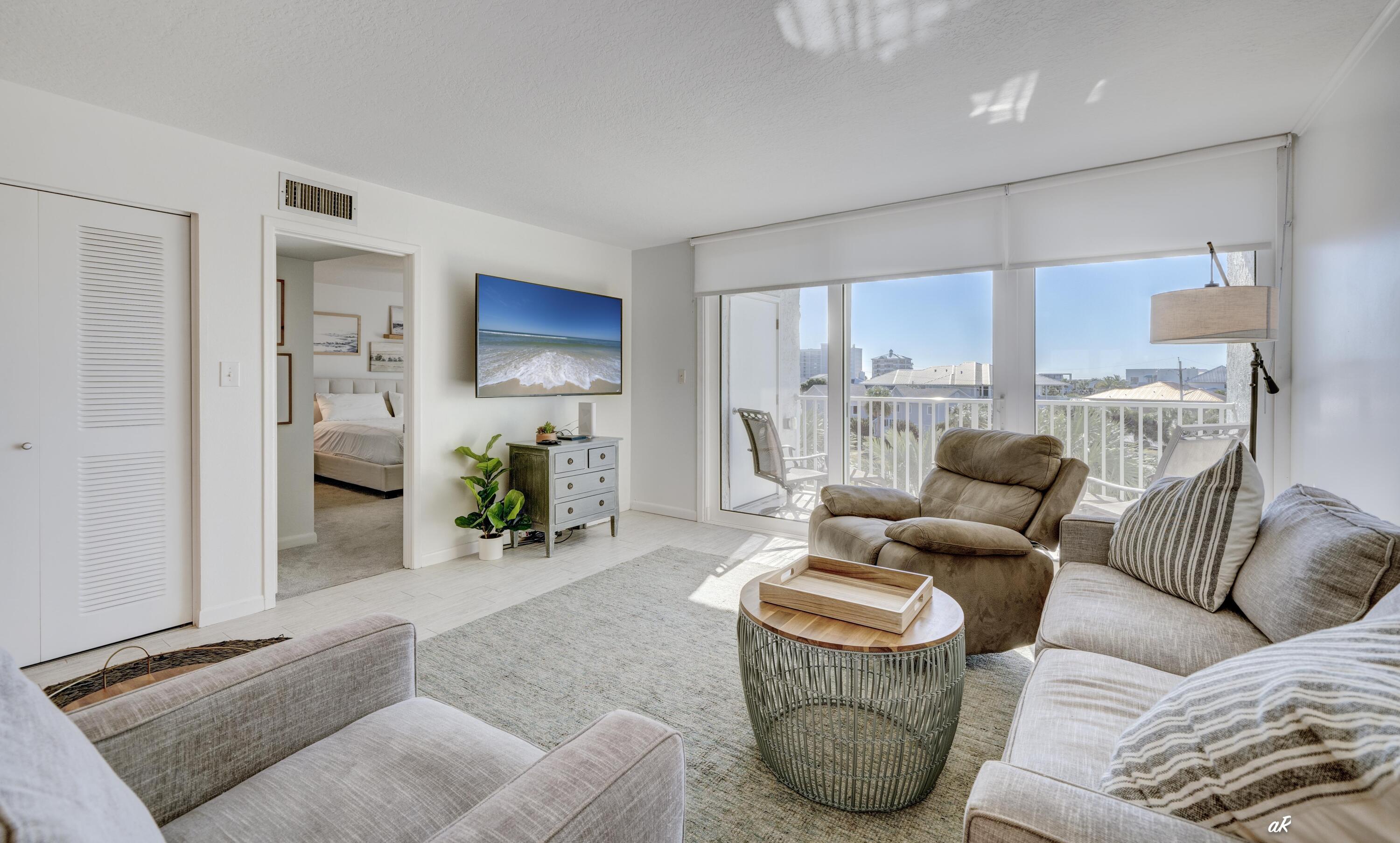 30 Moreno Point Road, Unit 404A Destin, FL 32541 - Photo 13 of 52 a living room with furniture a lamp and a window