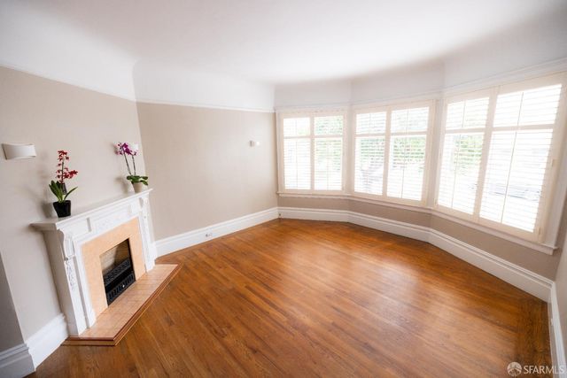 a living room with a fireplace and a potted plant