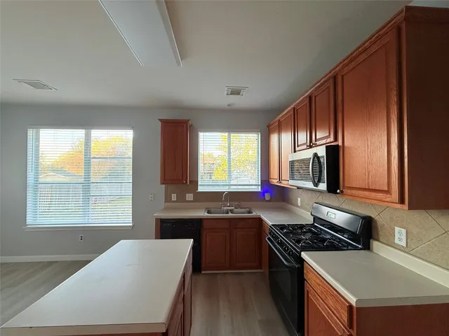 a view of a kitchen with a sink and a fireplace