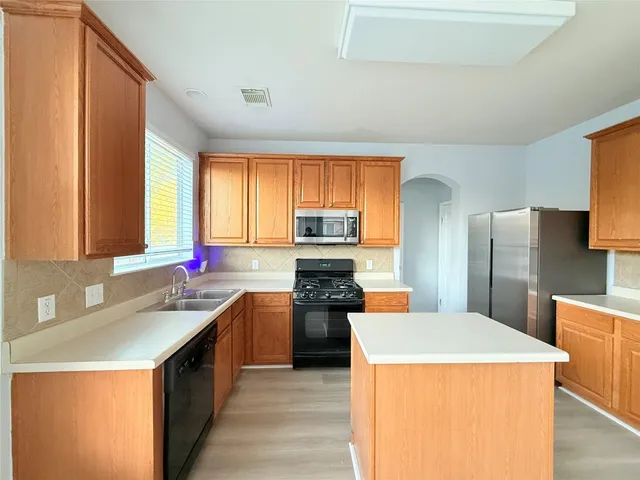 an empty room with windows and cabinet