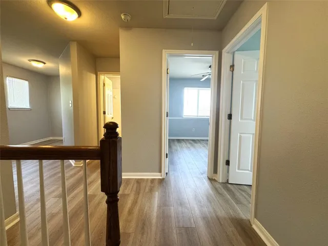 a view of a hallway with wooden floor