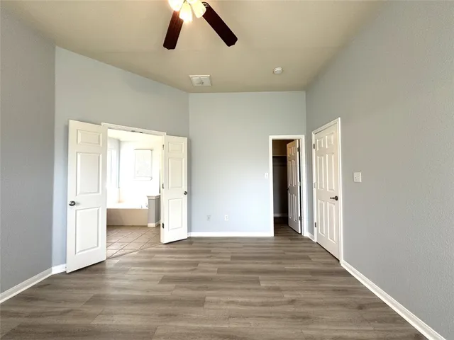 a view of empty room with wooden floor