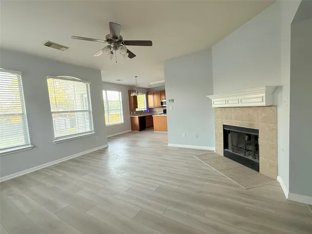 a view of an empty room with a fireplace and a window