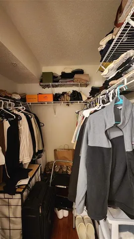 a view of walk in closet with clothes and shoes