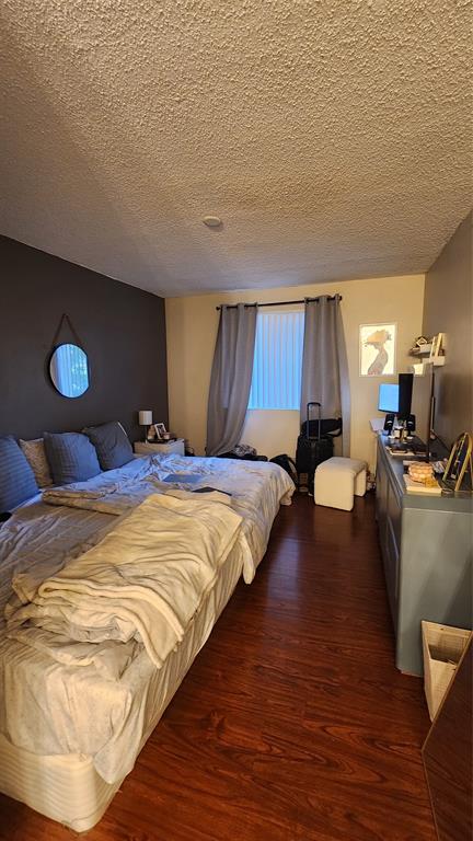 3874 Lyons Road, Unit 103 Pompano Beach, FL 33073 - Photo 15 of 27 a bed sitting in a bedroom and dressers next to a larger window