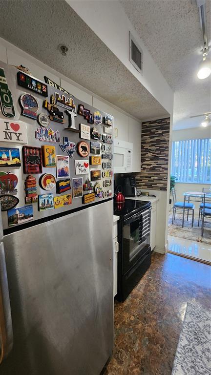 3874 Lyons Road, Unit 103 Pompano Beach, FL 33073 - Photo 4 of 27 a kitchen with stainless steel appliances granite countertop a refrigerator and a stove