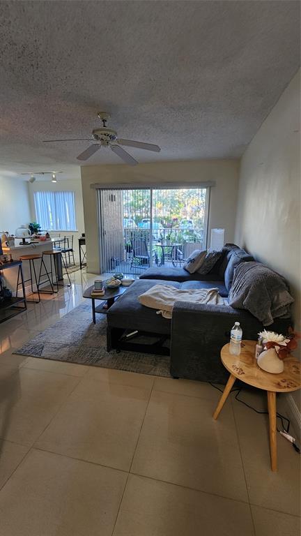 3874 Lyons Road, Unit 103 Pompano Beach, FL 33073 - Photo 7 of 27 a living room with furniture and a large window