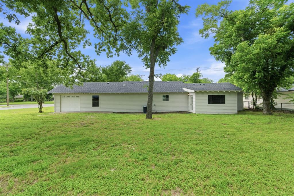 507 Country Club Road Cleburne, TX 76033 - Photo 36 of 39 Single-story residence featuring white siding, a dark shingle roof, and an attached garage with a panel door